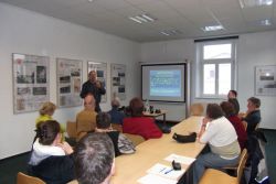 Jürgen Bartossek von Hörbiko (stehend) erklärt Zuhörern am Beispiel die Hochton-Schwerhörigkeit